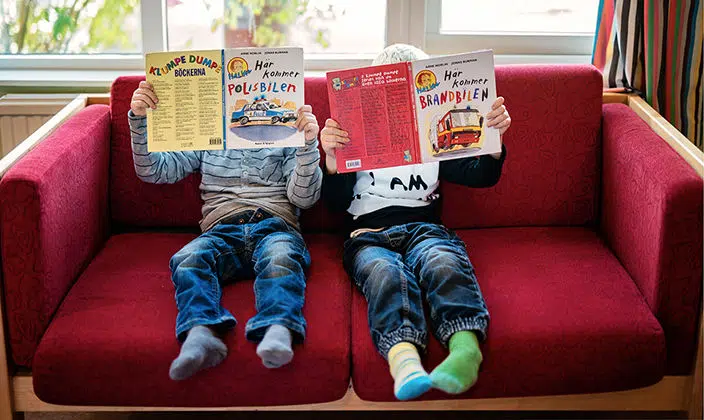 Kids on sofa reading educational books